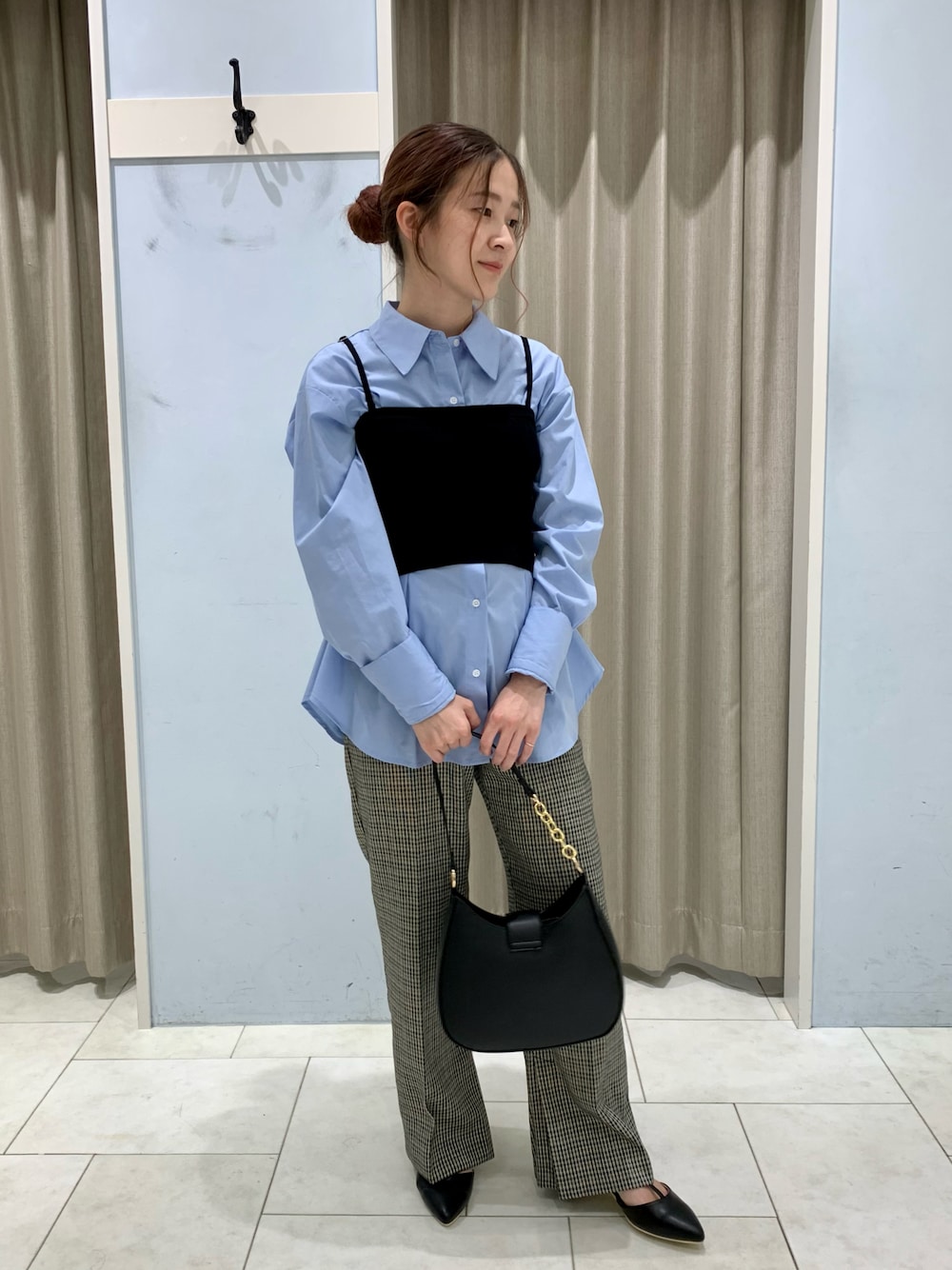 ブルー系のシャツ/ブラウス、ブラック系のニット/セーター、ブラウン系のその他パンツを着用したレディースの秋コーディネートの1枚目の写真