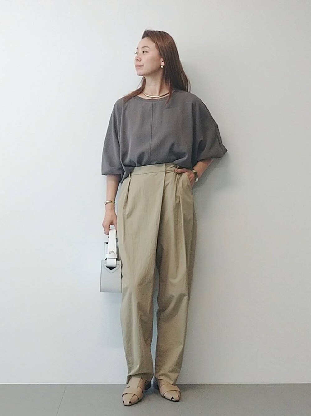 ホワイト系のハンドバッグ、ベージュ系のその他パンツ、ベージュ系のパンプスを着用したレディースの冬コーディネートの1枚目の写真