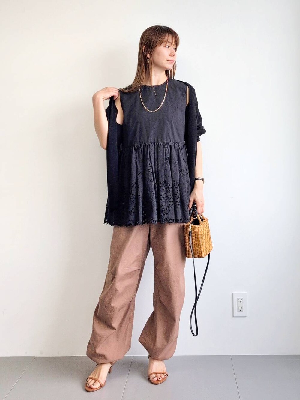 イエロー系のカーゴパンツ、ブラック系のショルダーバッグ、ブラウン系のサンダルを着用したレディースの夏コーディネートの1枚目の写真