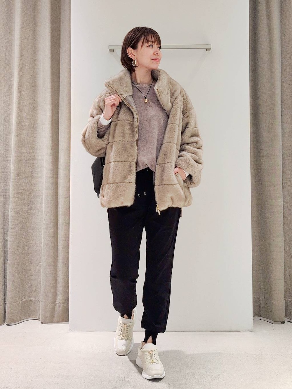 ブラック系のショルダーバッグ、ベージュ系のブルゾン、ブラック系のその他パンツを着用したレディースの秋コーディネートの1枚目の写真