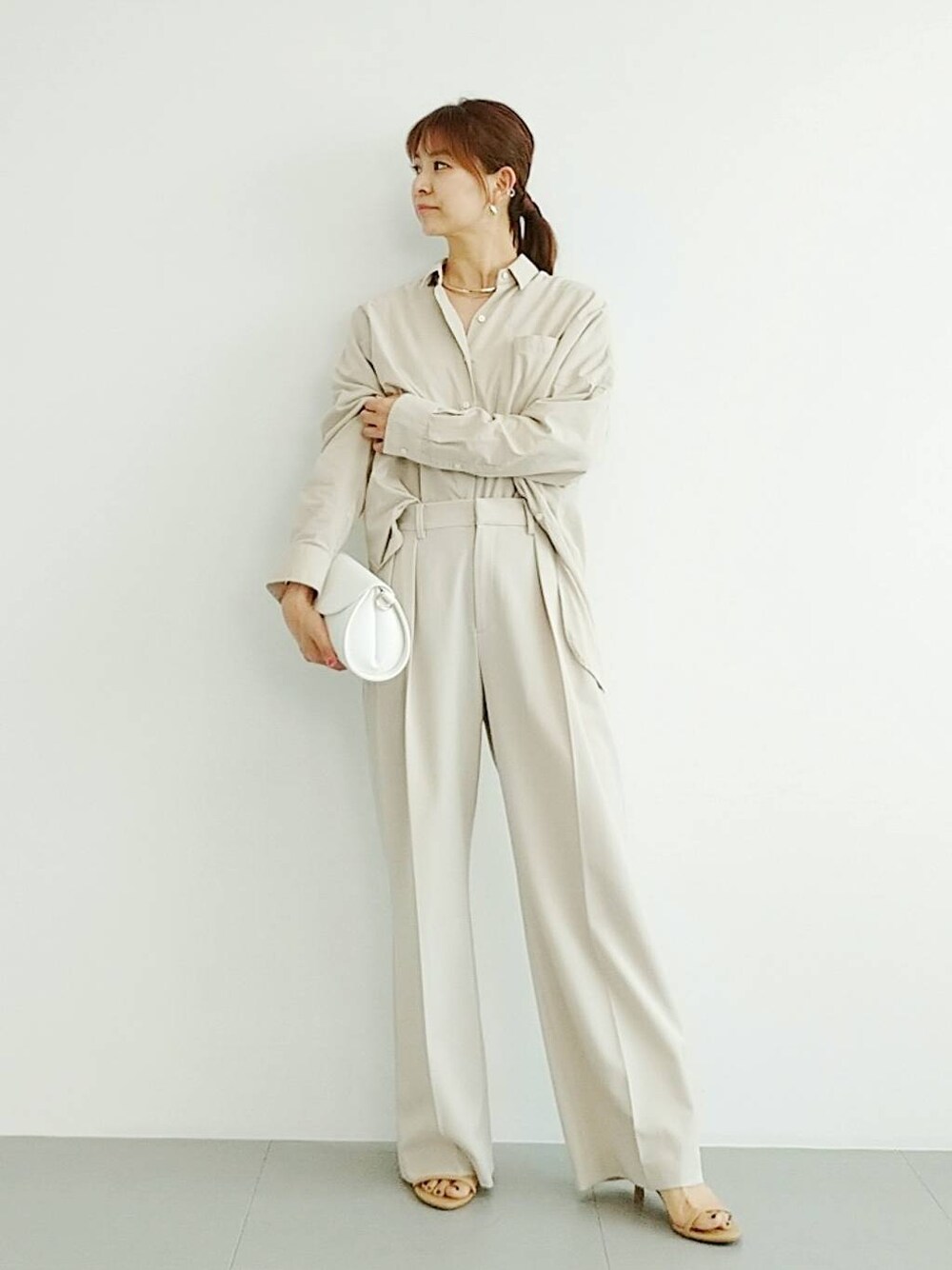 ベージュ系のスリッポン、ベージュ系のスラックス、その他のチョーカーを着用したレディースの夏コーディネートの1枚目の写真