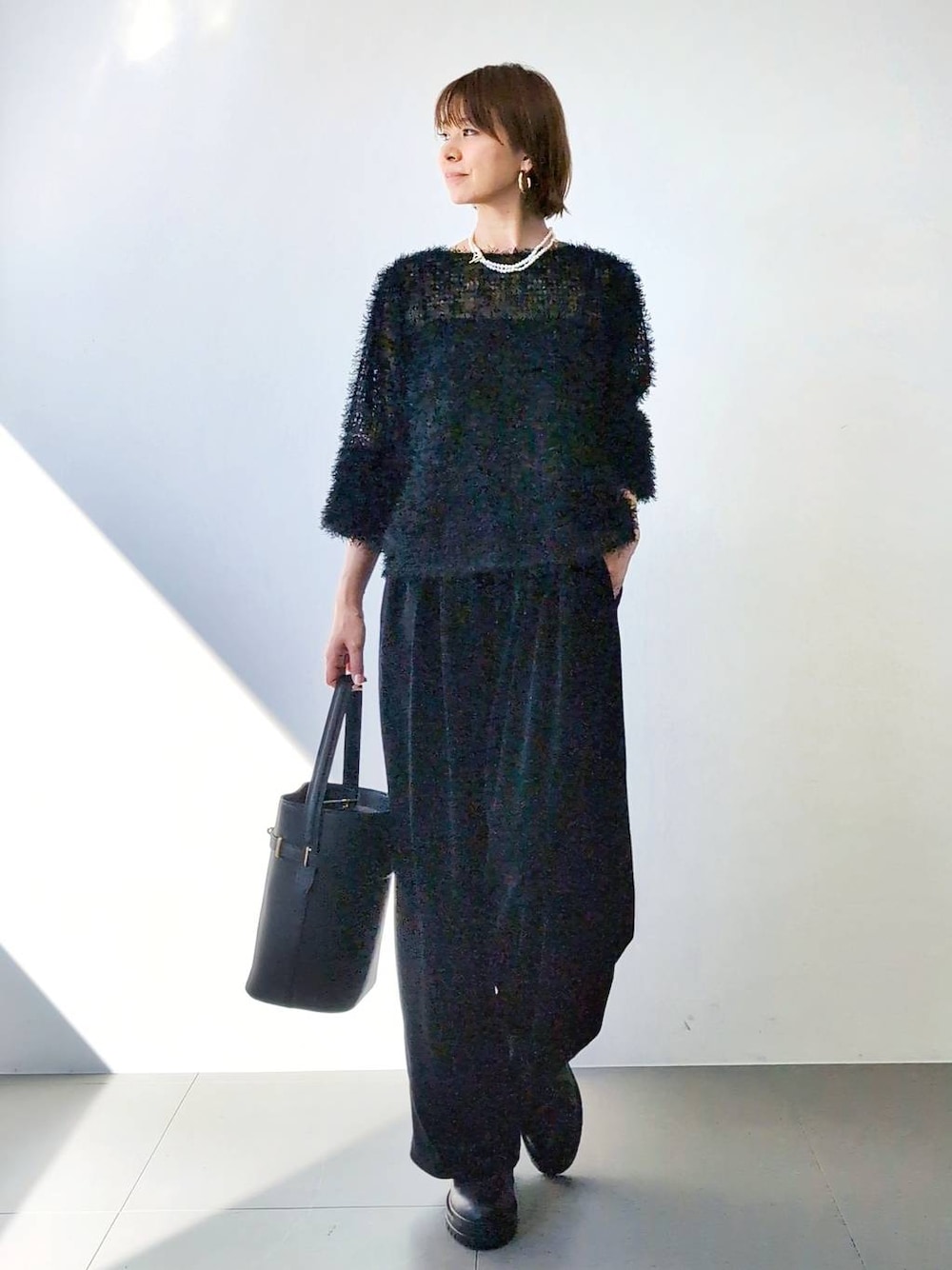 ブラック系のブーツ、ブラック系のハンドバッグ、ブラック系のキャミソールを着用したレディースの冬コーディネートの1枚目の写真