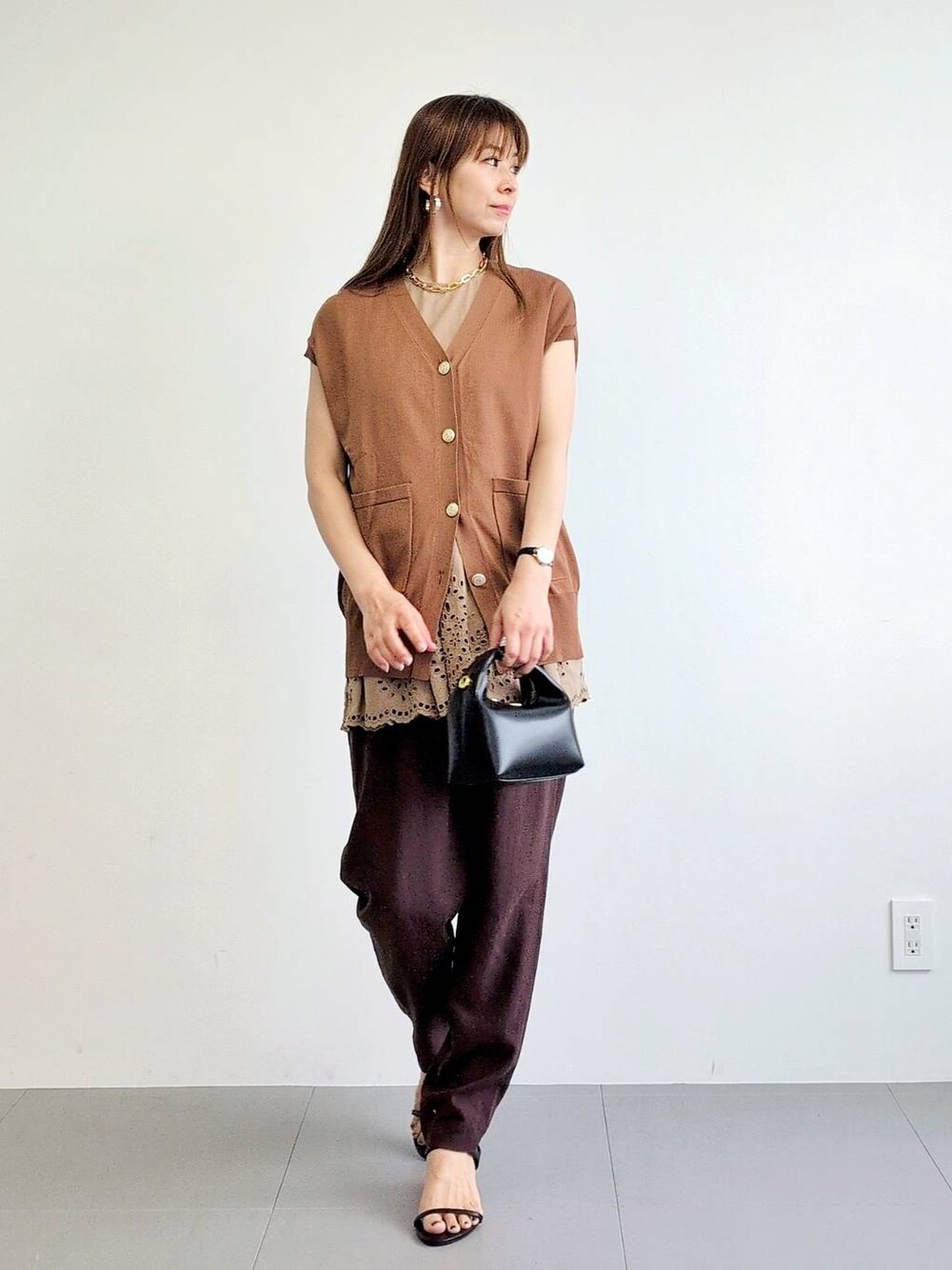 ブラック系のサンダル、ブラウン系のその他パンツ、イエロー系のニット/セーターを着用したレディースの夏コーディネートの1枚目の写真