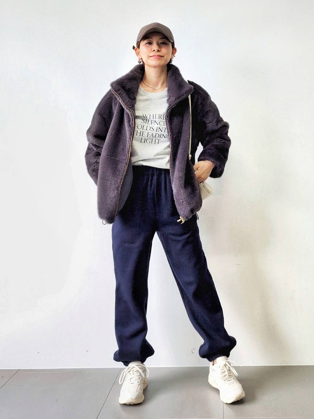 ホワイト系のショルダーバッグ、グレー系のブルゾン、ホワイト系のスニーカーを着用したレディースの秋コーディネートの1枚目の写真