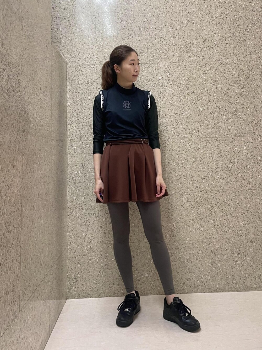 ブラック系のTシャツ/カットソー、ブラウン系のスカートを着用したレディースの秋コーディネートの1枚目の写真