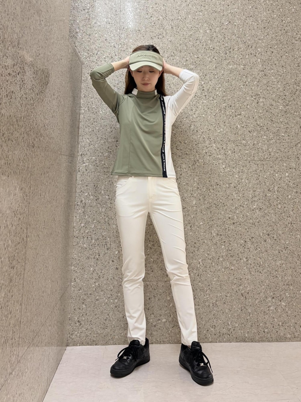 グリーン系のTシャツ/カットソー、ホワイト系のその他パンツ、グリーン系のサンバイザーを着用したレディースの秋コーディネートの1枚目の写真