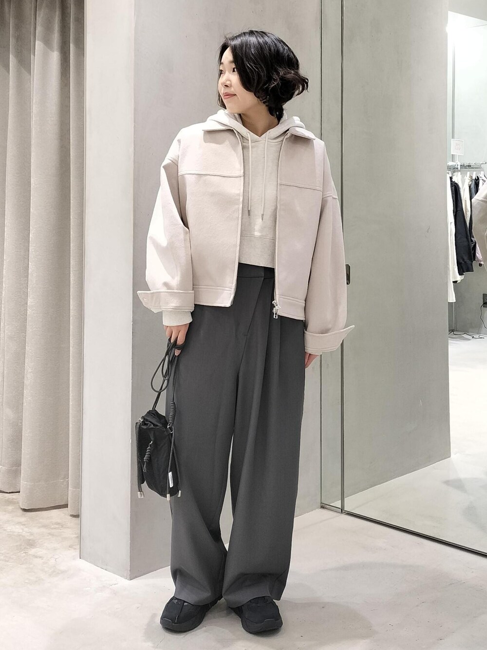 ベージュ系のその他アウター、グレー系のスラックス、ホワイト系のパーカーを着用したレディースの冬コーディネートの1枚目の写真