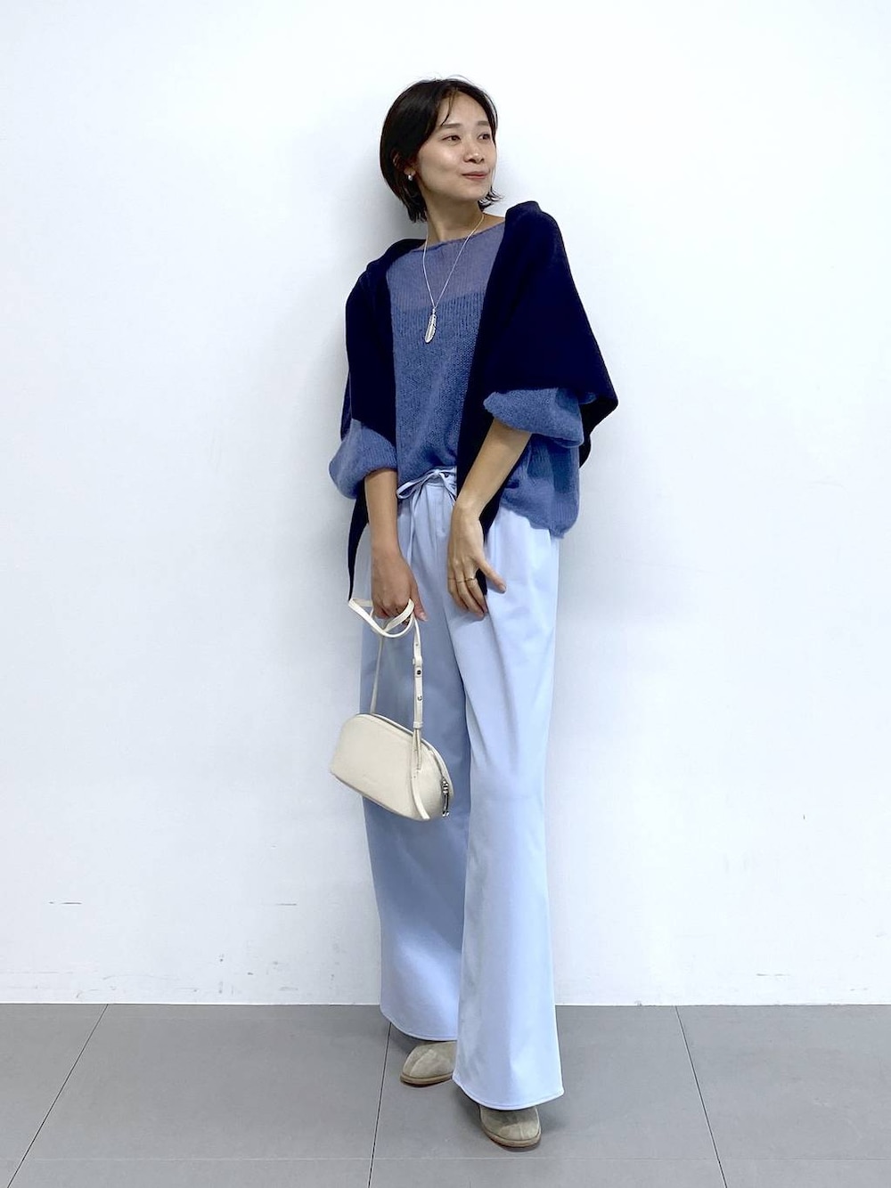 ホワイト系のショルダーバッグ、ベージュ系のブーツ、ブルー系のその他パンツを着用したレディースの秋コーディネートの1枚目の写真