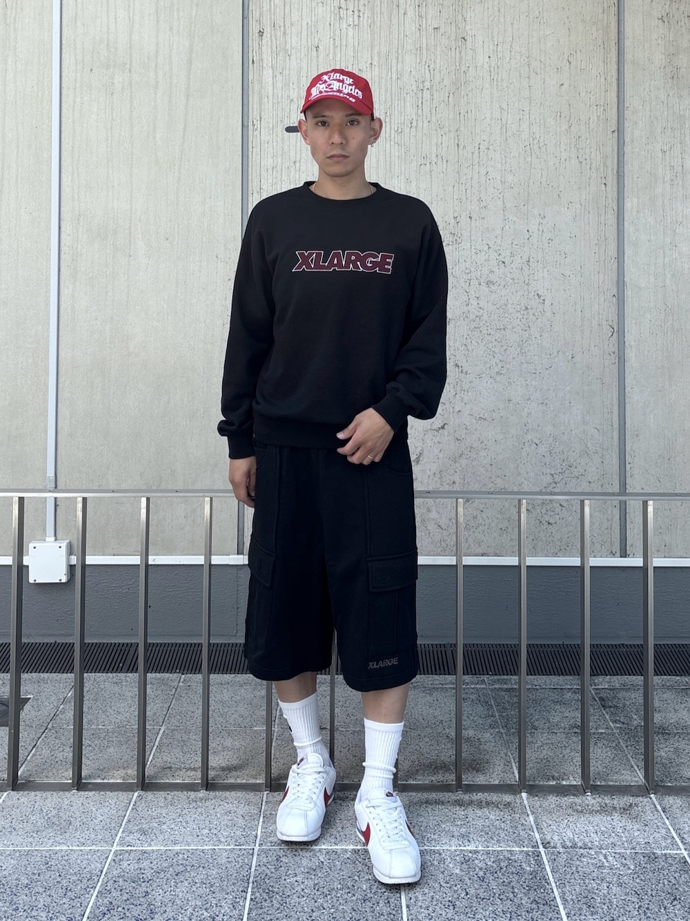 ブラック系のスウェット、ブラック系のスウェットパンツ、レッド系のキャップを着用したメンズの秋コーディネートの1枚目の写真