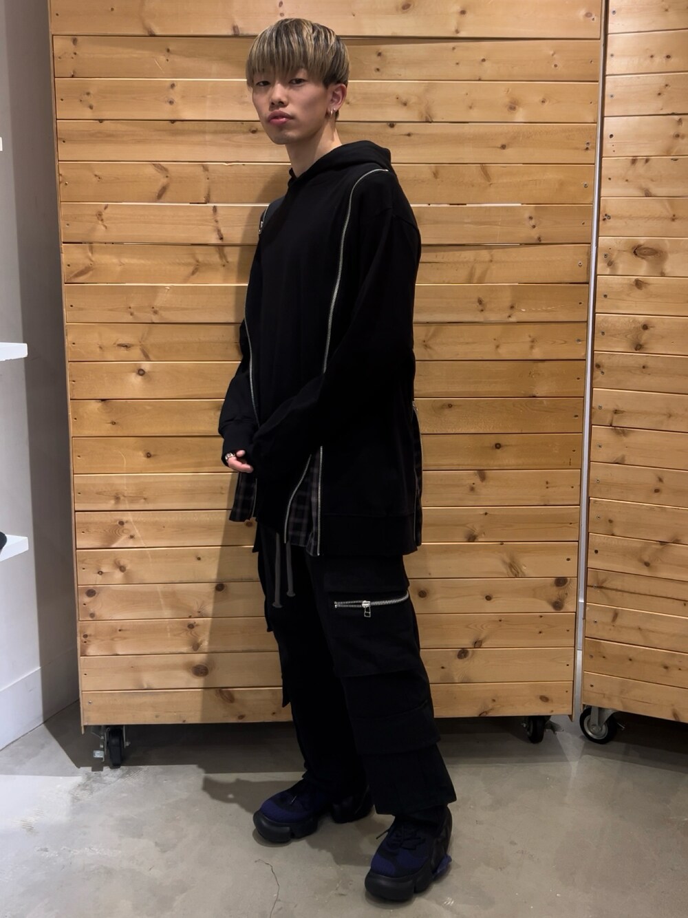 ブラック系のカーゴパンツ、パープル系のスニーカー、ブラック系のパーカーを着用したメンズの春コーディネートの1枚目の写真
