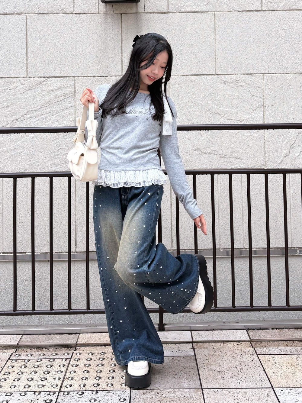 ブルー系のその他パンツ、グレー系のTシャツ/カットソー、ホワイト系のショルダーバッグを着用したレディースの冬コーディネートの1枚目の写真