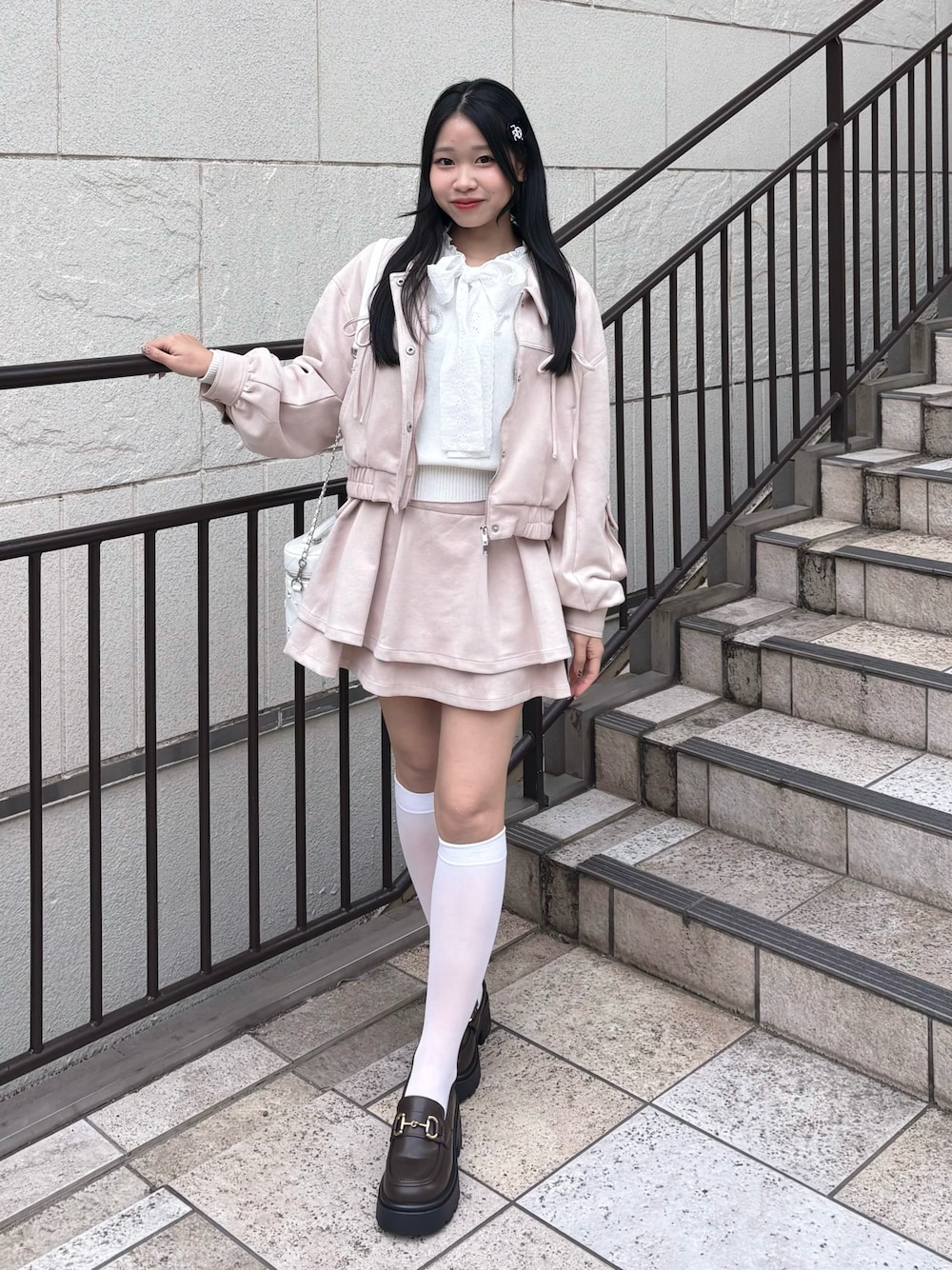 ピンク系のブルゾン、ピンク系のスカート、ホワイト系のニット/セーターを着用したレディースの冬コーディネートの1枚目の写真