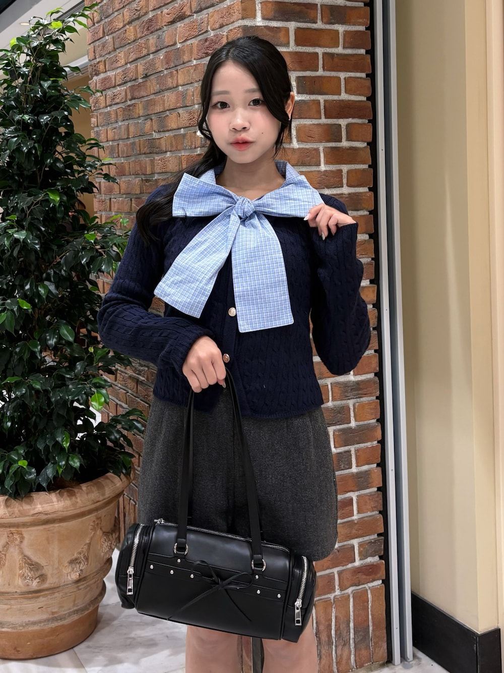 ブルー系のニット/セーター、グレー系のその他パンツ、ブラック系のトートバッグを着用したレディースの冬コーディネートの1枚目の写真