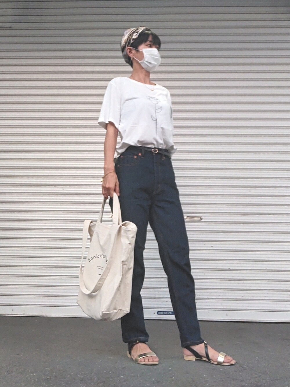 ホワイト系のTシャツ/カットソー、ブルー系のデニムパンツ、ブラック系のサンダルを着用したレディースの夏コーディネートの1枚目の写真