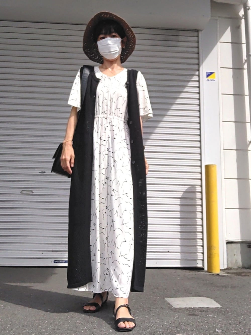 ホワイト系のワンピース、ブラック系のサンダル、ブラック系のジャケット/アウターを着用したレディースの夏コーディネートの1枚目の写真