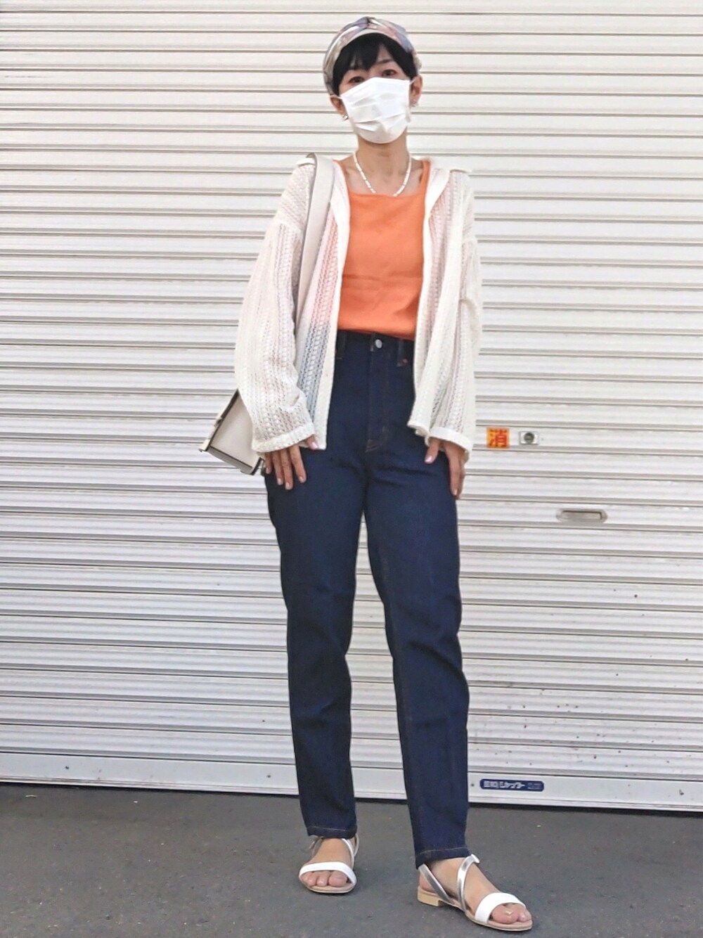 オレンジ系のタンクトップ、ホワイト系のシャツ/ブラウス、ブルー系のデニムパンツを着用したレディースの夏コーディネートの1枚目の写真