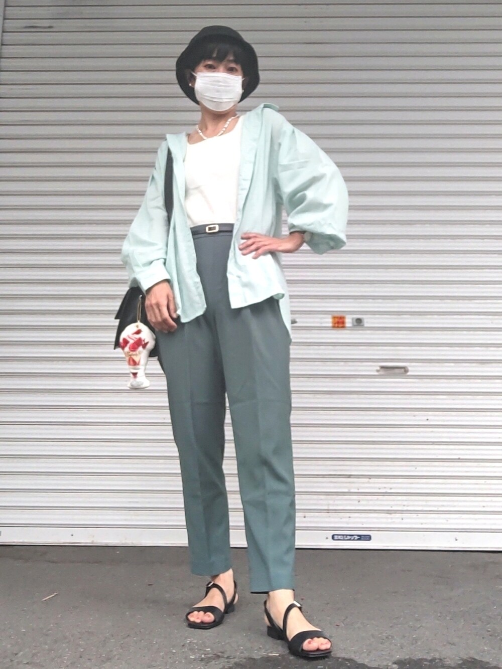 ホワイト系のタンクトップ、グリーン系のシャツ/ブラウス、グリーン系のスラックスを着用したレディースの夏コーディネートの1枚目の写真