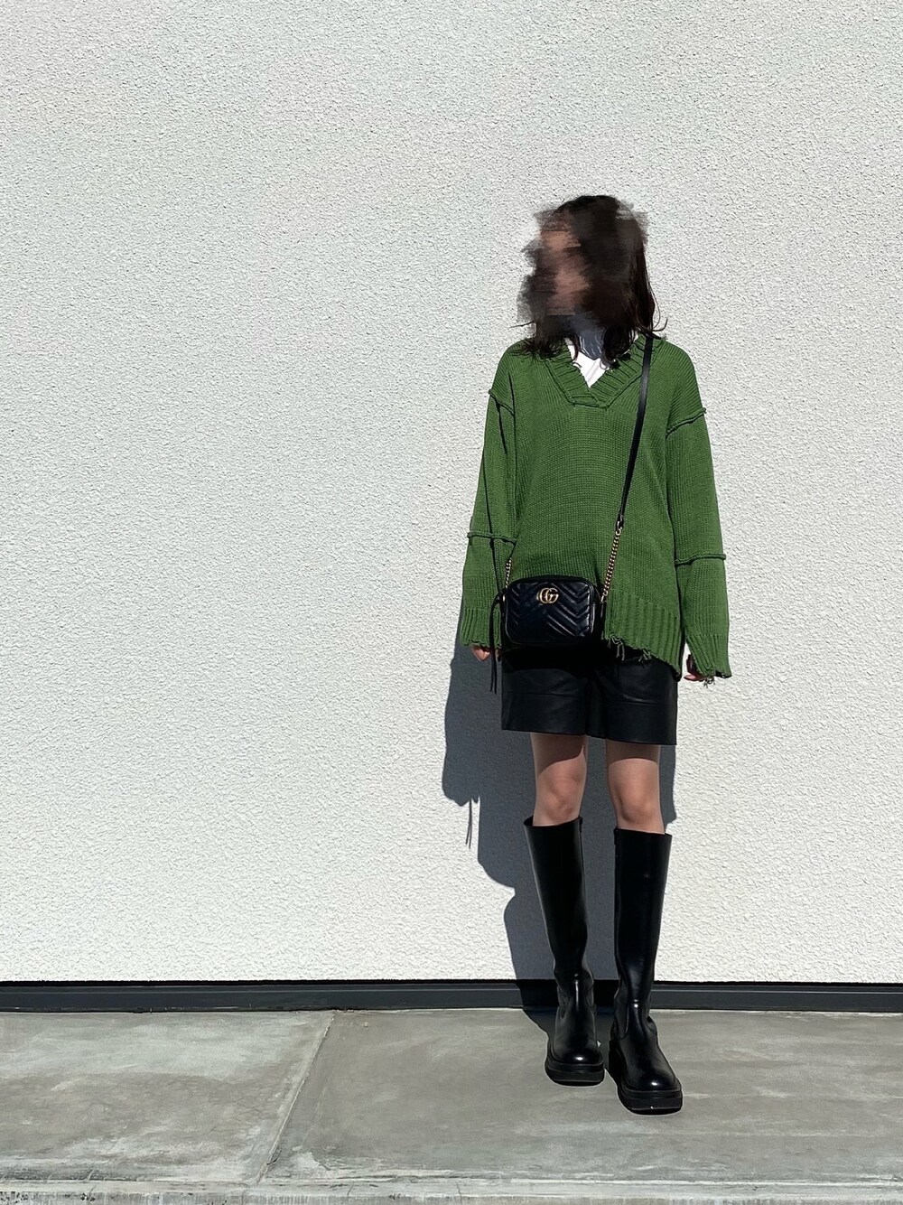 ブラック系のブーツ、ブラック系のその他パンツ、グリーン系のニット/セーターを着用したレディースの冬コーディネートの1枚目の写真