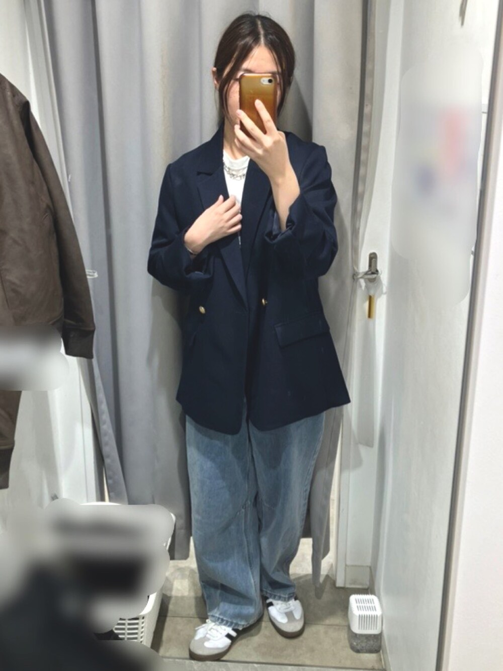 ブルー系のデニムパンツ、ブルー系のテーラードジャケット、ホワイト系のスニーカーを着用したレディースの秋コーディネートの1枚目の写真