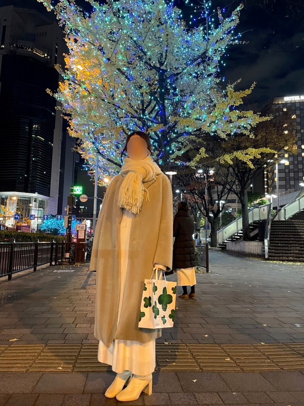 ホワイト系のブーツ、グレー系のチェスターコート、ホワイト系のワンピースを着用したレディースの冬コーディネートの1枚目の写真