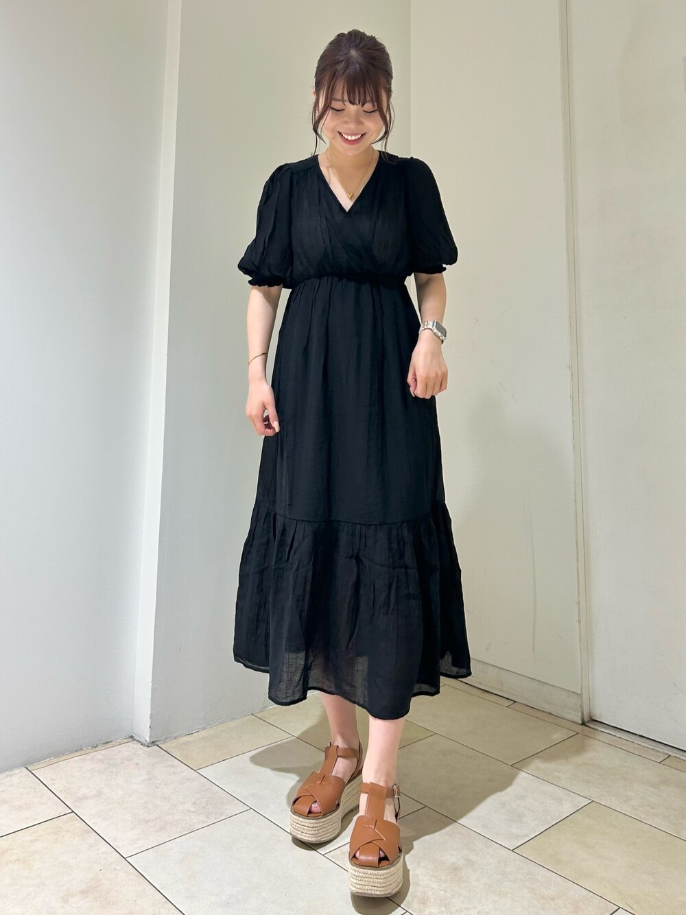 ブラック系のワンピース、ブラウン系のサンダルを着用したレディースの夏コーディネートの1枚目の写真