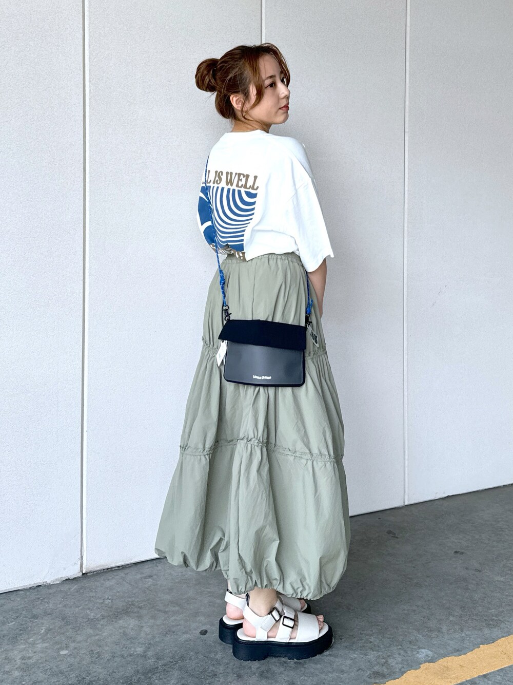 ホワイト系のTシャツ/カットソー、グリーン系のスカート、ブラック系のショルダーバッグを着用したレディースの夏コーディネートの1枚目の写真