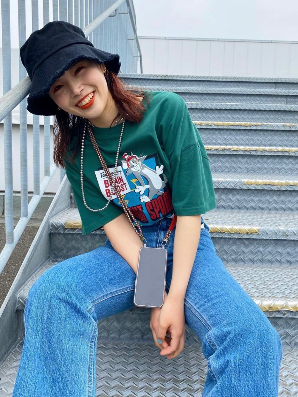 グリーン系のTシャツ/カットソー、ブルー系のデニムパンツ、シルバー系のネックレスを着用したレディースの春コーディネートの1枚目の写真