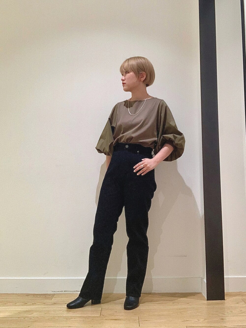 ブラック系のデニムパンツ、ブラック系のブーツ、グリーン系のTシャツ/カットソーを着用したレディースの秋コーディネートの1枚目の写真