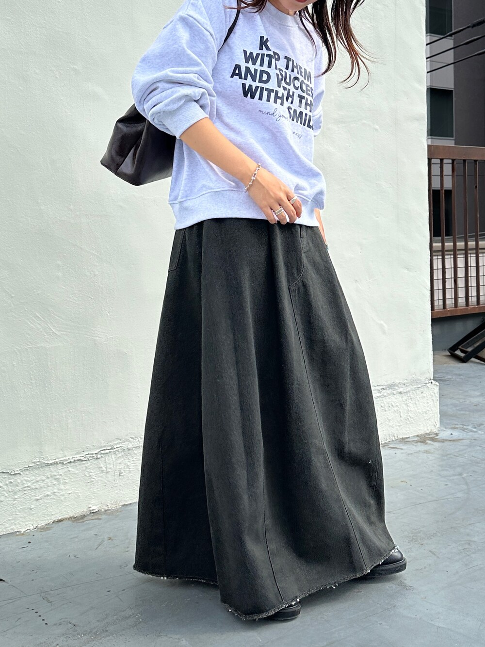 グレー系のデニムスカートを着用したレディースの秋コーディネートの1枚目の写真