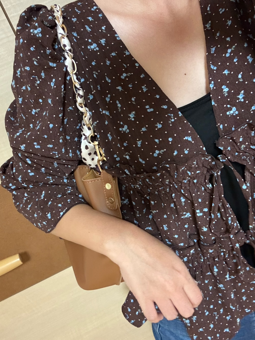 ブラウン系のシャツ/ブラウス、ブラック系のサンダル、ブルー系のデニムパンツを着用したレディースの秋コーディネートの1枚目の写真