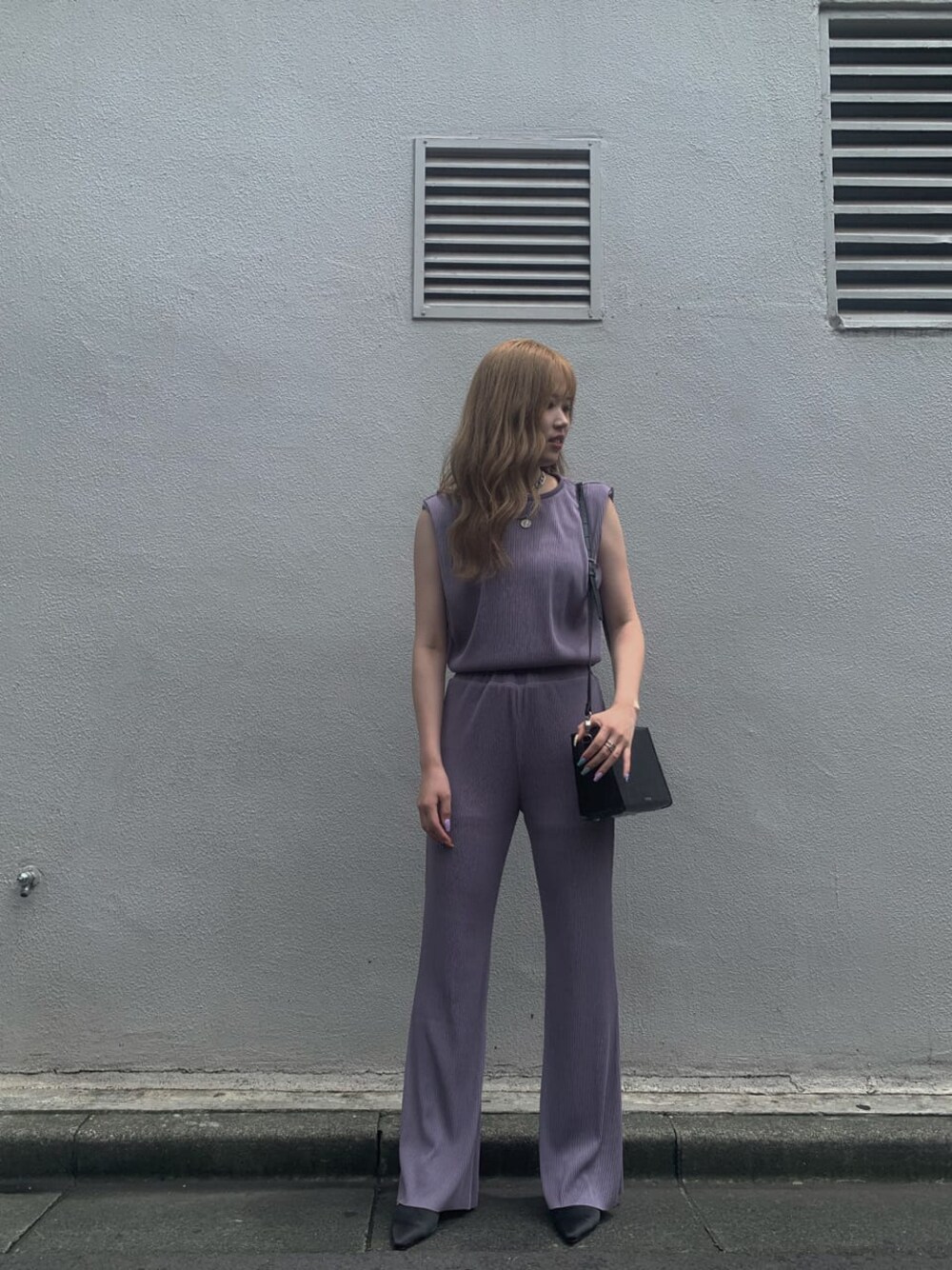 ブラック系のサンダル、パープル系のTシャツ/カットソー、パープル系のスラックスを着用したレディースの夏コーディネートの1枚目の写真