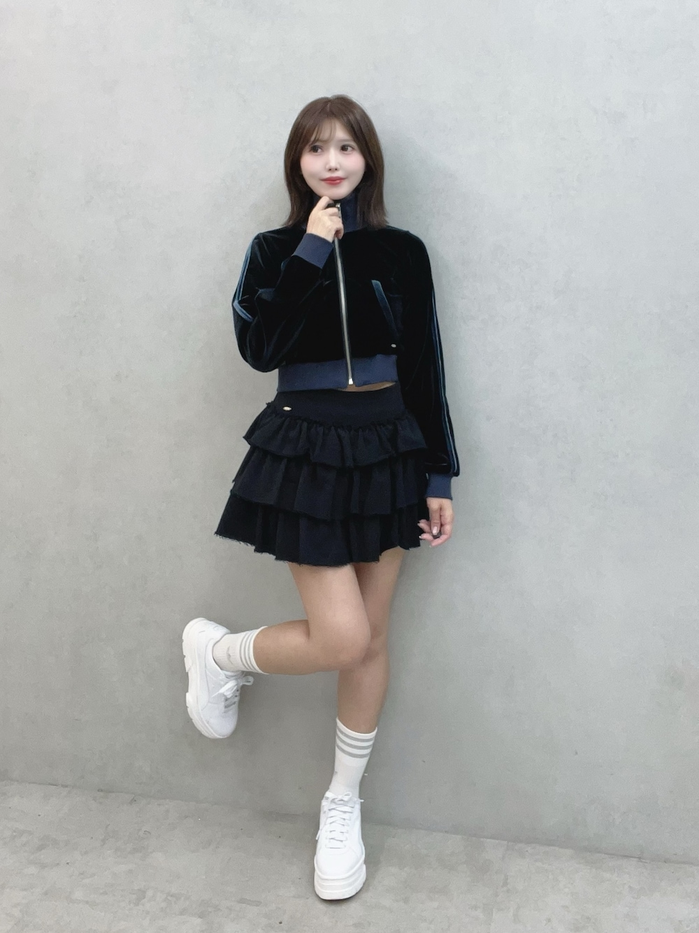 ブラック系のブルゾン、ブラック系のスカート、ホワイト系のスニーカーを着用したレディースの秋コーディネートの1枚目の写真