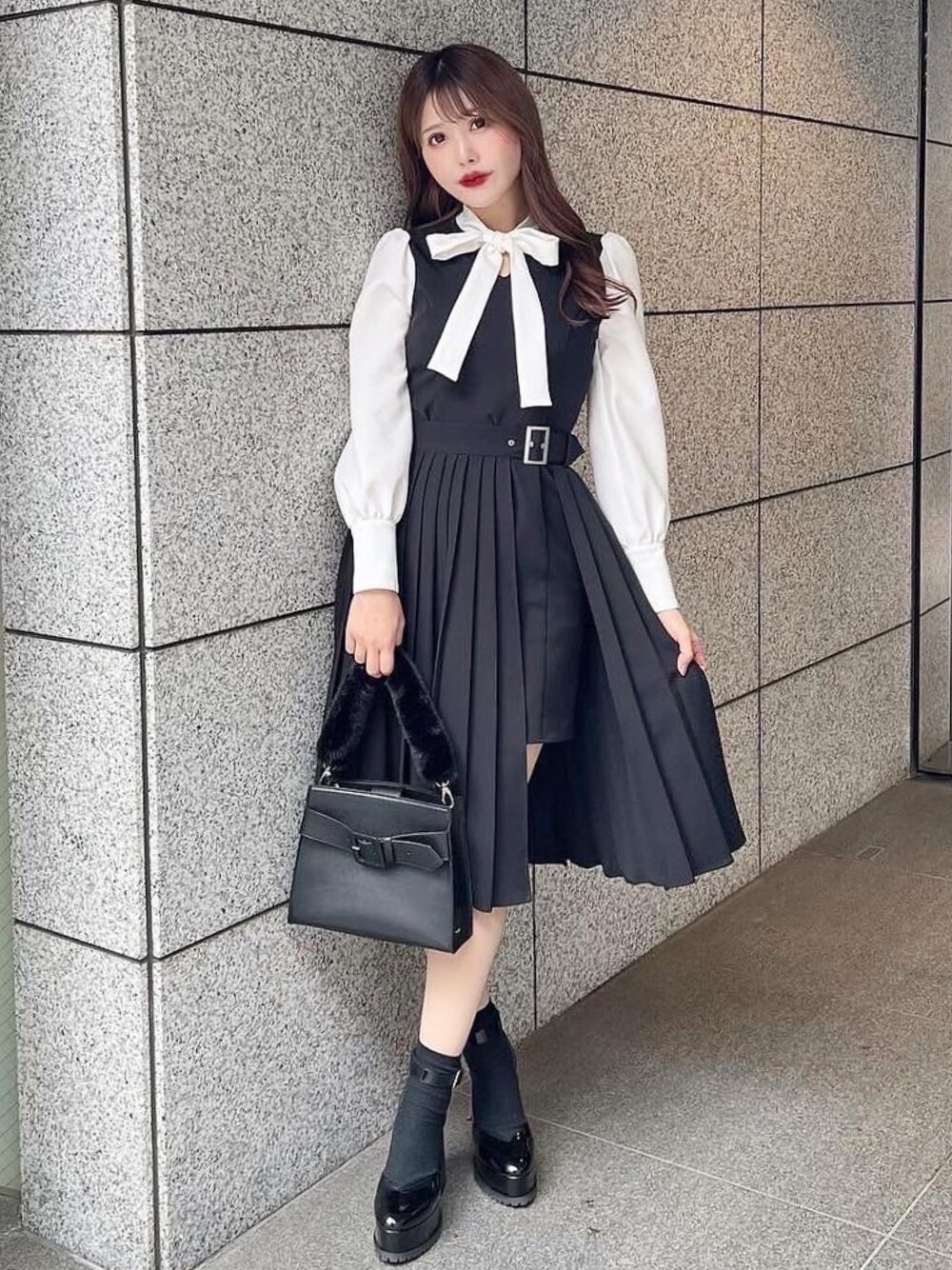 ブラック系のワンピース、ブラック系のハンドバッグ、その他のパンプスを着用したレディースの冬コーディネートの1枚目の写真