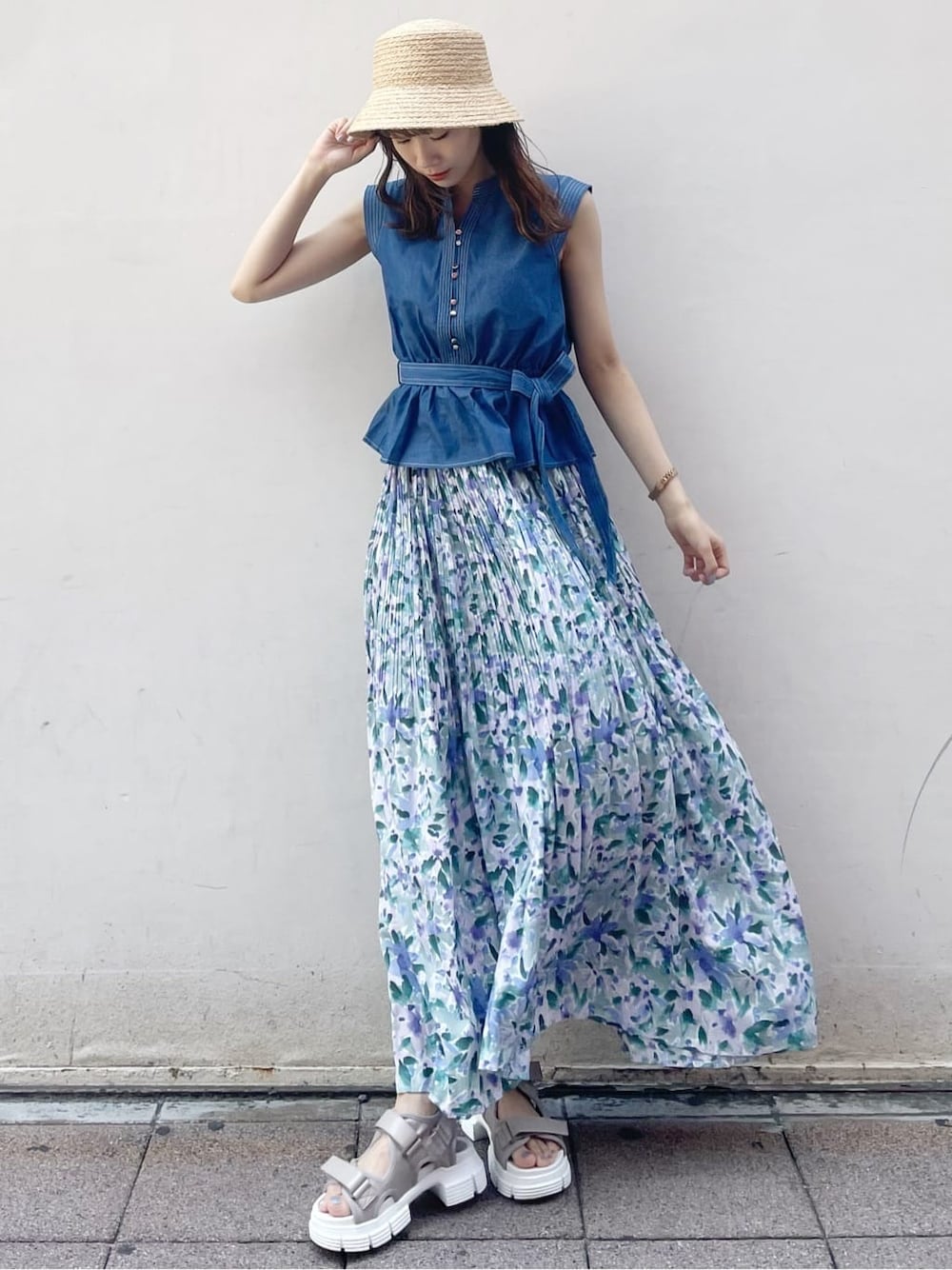 ブルー系のスカート、ベージュ系のサンダル、ブルー系のシャツ/ブラウスを着用したレディースの夏コーディネートの1枚目の写真