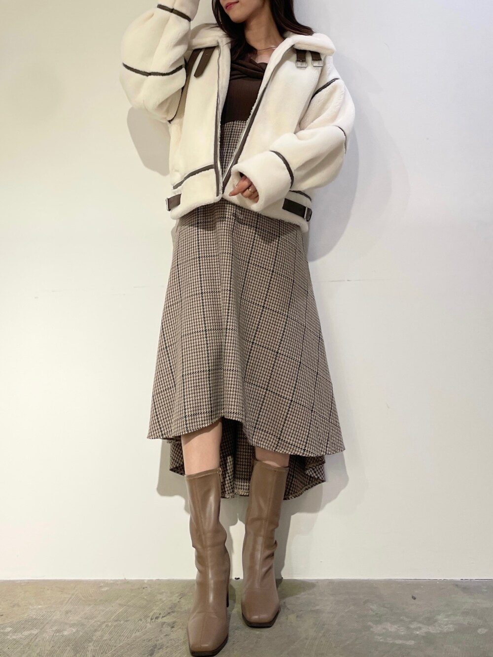 ブラウン系のワンピース、ベージュ系のブーツ、ホワイト系のブルゾンを着用したレディースの秋コーディネートの1枚目の写真
