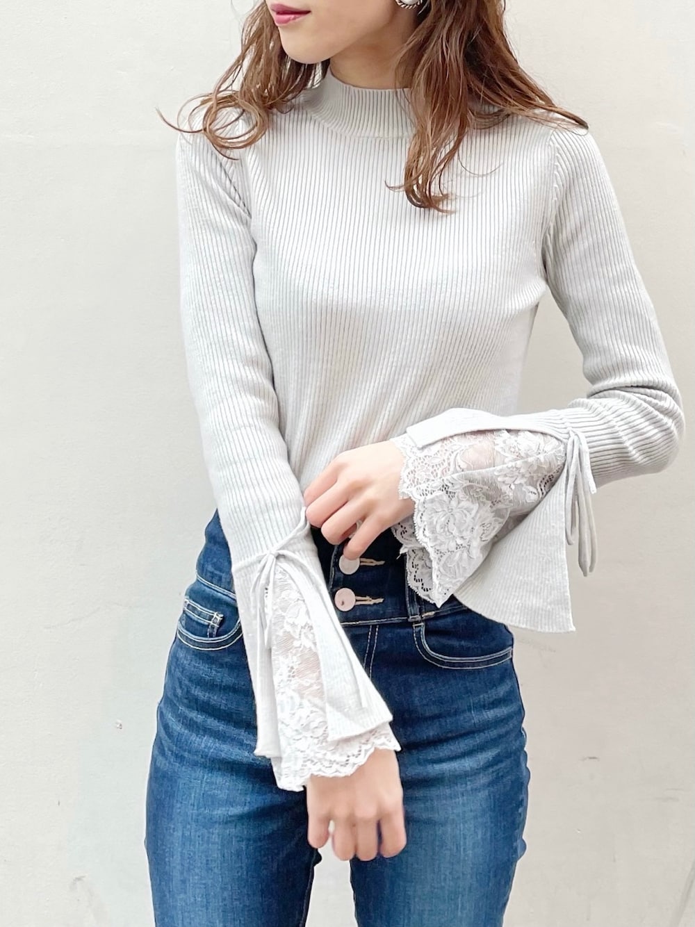 ブルー系のデニムパンツ、ブラック系のブーツ、グレー系のニット/セーターを着用したレディースの冬コーディネートの1枚目の写真