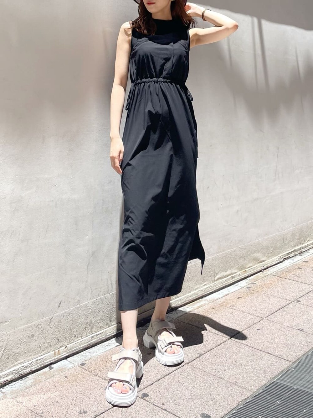 ブラック系のワンピース、ホワイト系のサンダルを着用したレディースの夏コーディネートの1枚目の写真
