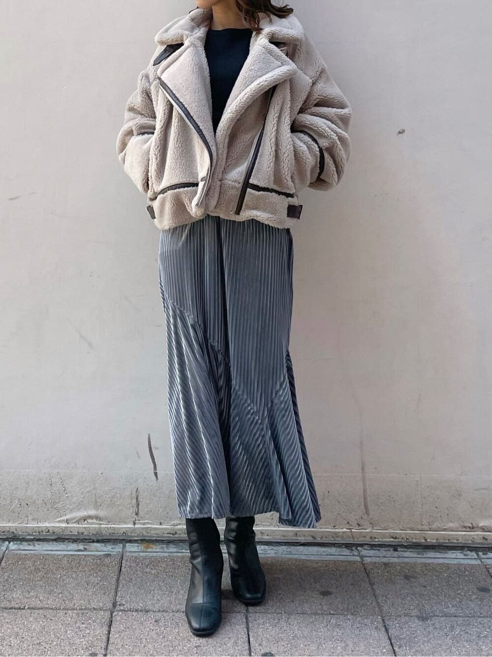 ベージュ系のブルゾン、ブラック系のブーツ、ブルー系のスカートを着用したレディースの秋コーディネートの1枚目の写真