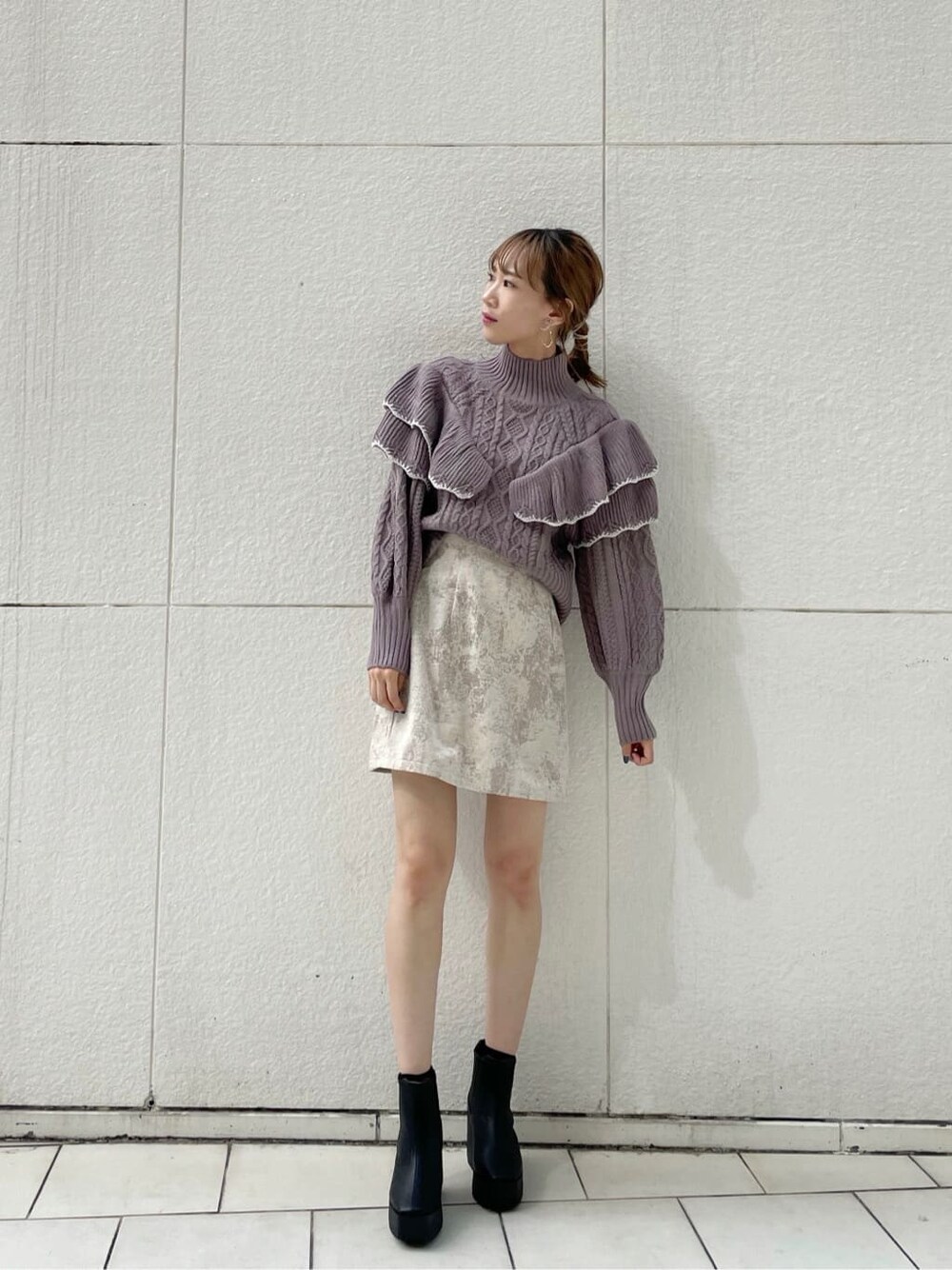 ベージュ系のスカート、ブラック系のブーツ、パープル系のニット/セーターを着用したレディースの秋コーディネートの1枚目の写真