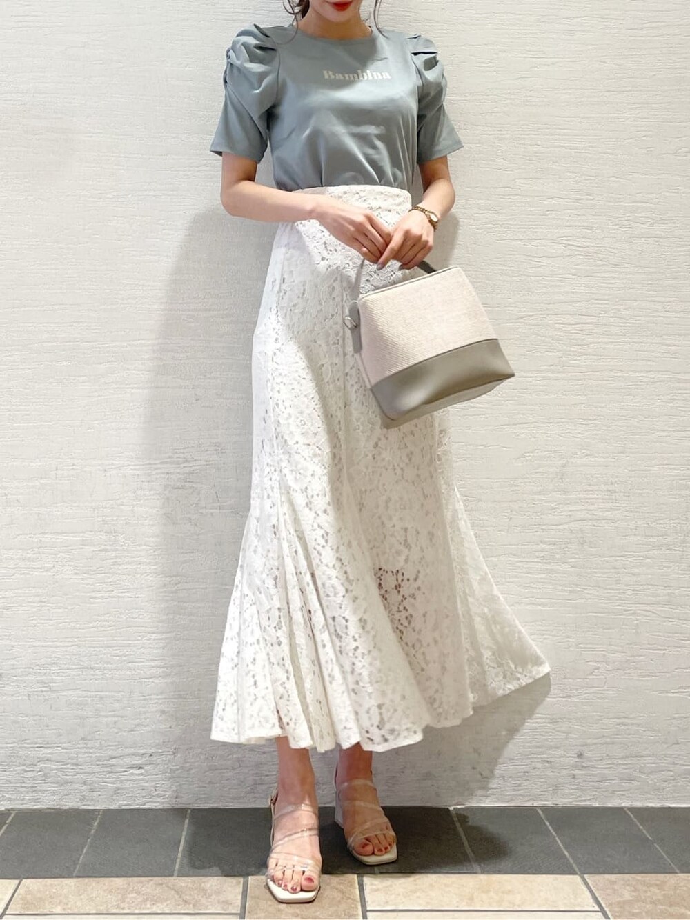 パープル系のサンダル、ホワイト系のスカート、グリーン系のTシャツ/カットソーを着用したレディースの春コーディネートの1枚目の写真
