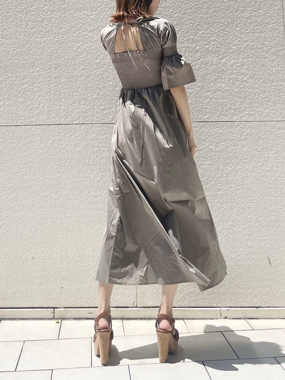 ブラウン系のサンダル、ベージュ系のワンピースを着用したレディースの夏コーディネートの1枚目の写真