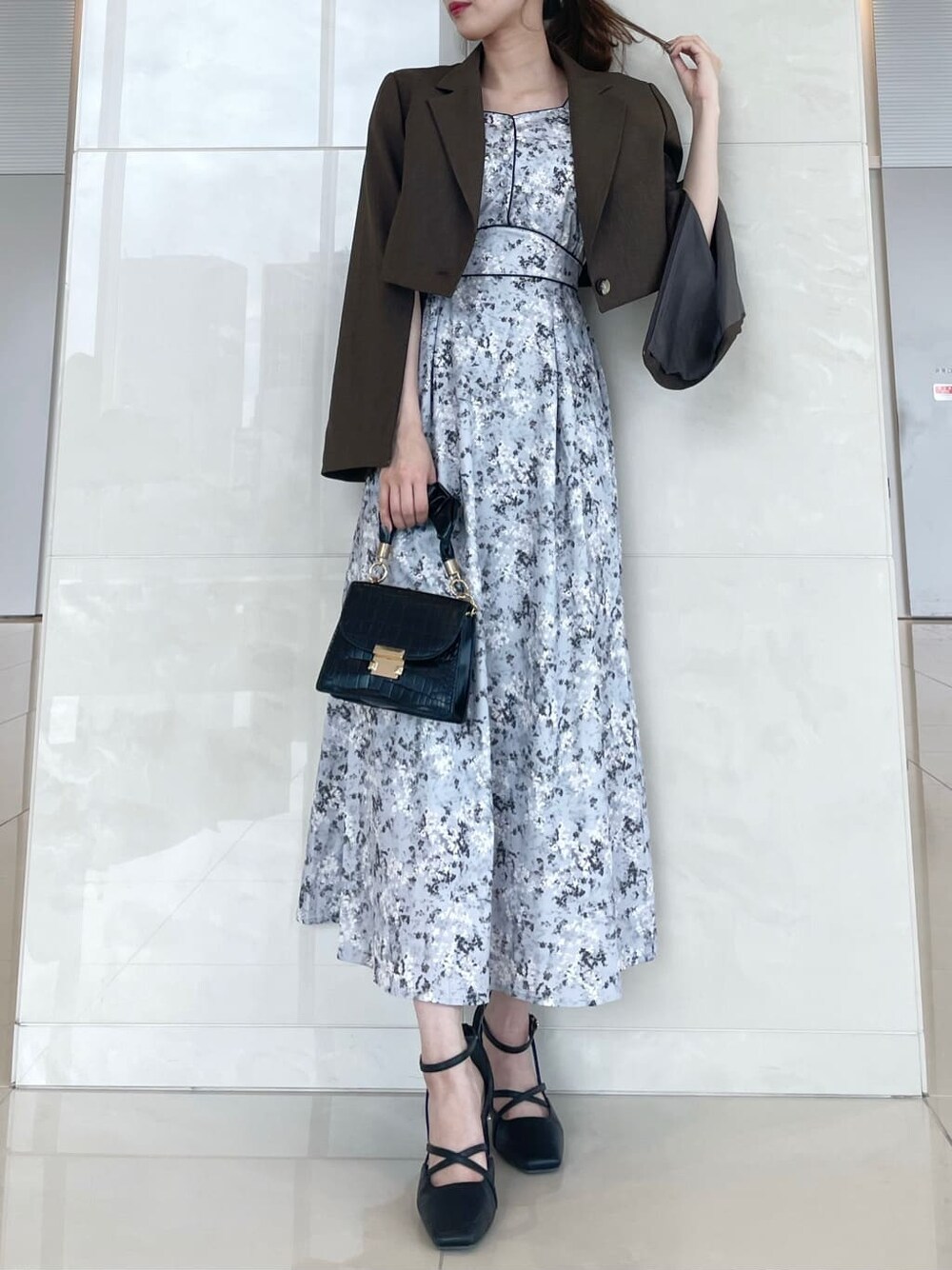 ブラウン系のその他アウター、ブラック系のパンプス、グレー系のワンピースを着用したレディースの秋コーディネートの1枚目の写真