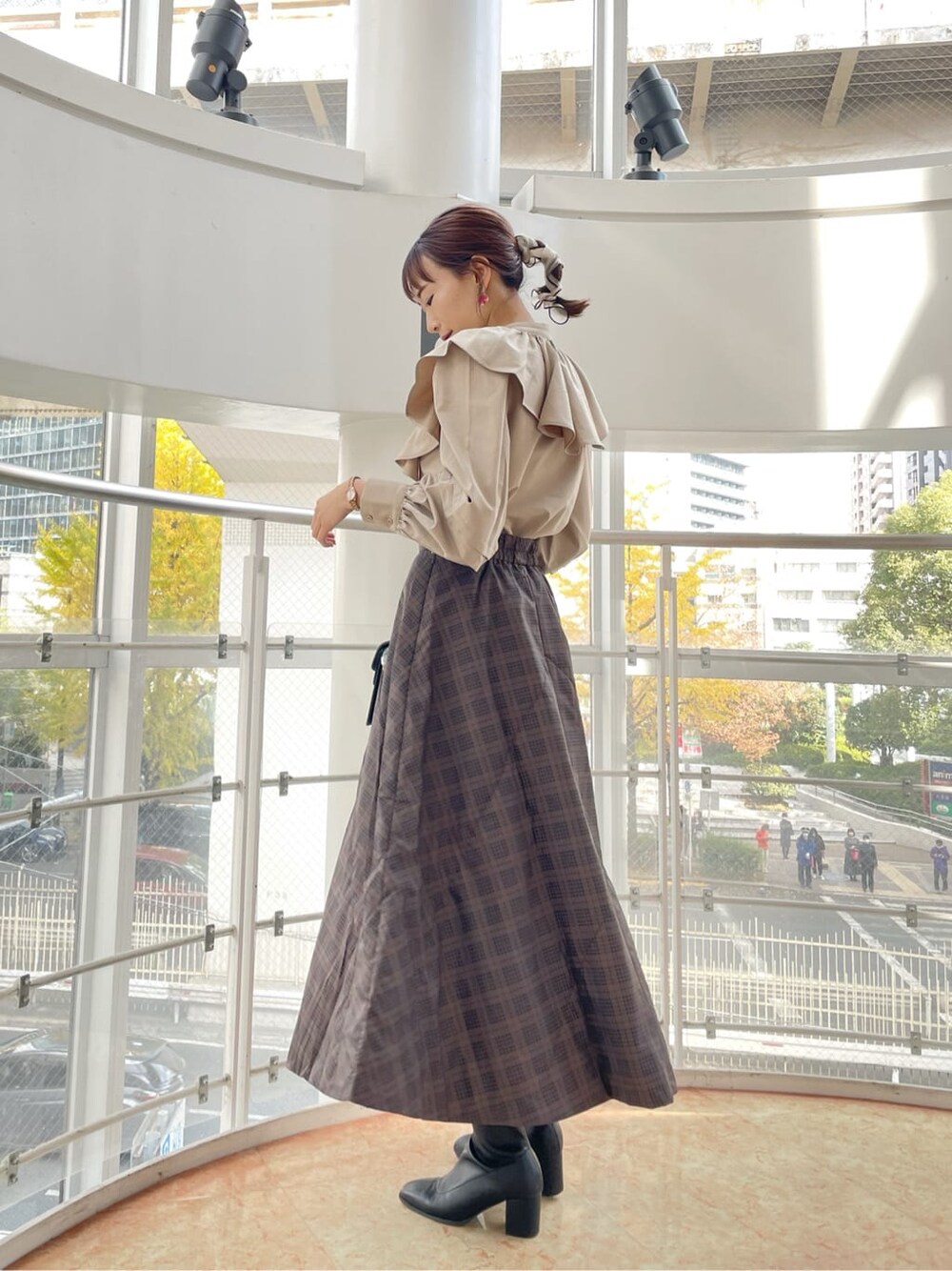 ブラック系のブーツ、ブラウン系のスカート、ベージュ系のシャツ/ブラウスを着用したレディースの冬コーディネートの1枚目の写真