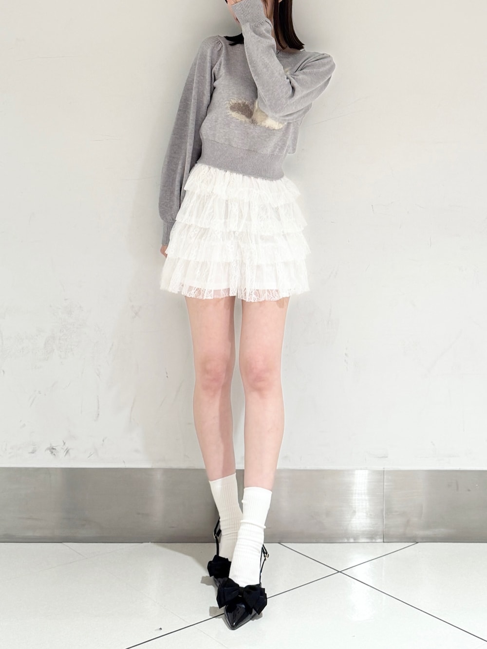 ブラック系のパンプス、ホワイト系のその他パンツ、グレー系のニット/セーターを着用したレディースの春コーディネートの1枚目の写真