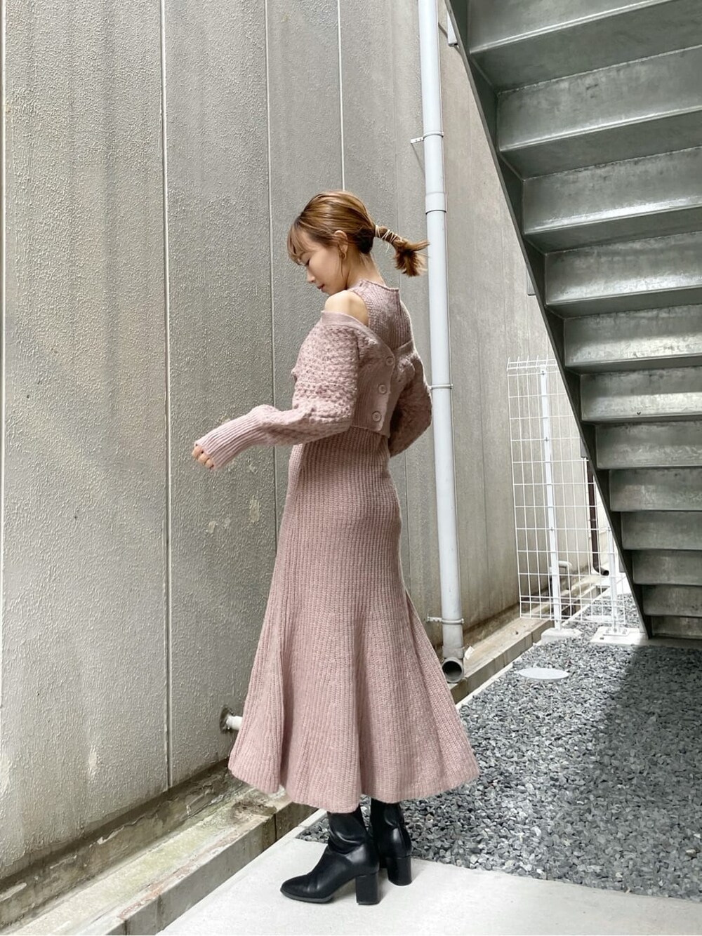 ベージュ系のワンピース、ブラック系のブーツ、ベージュ系のハンドバッグを着用したレディースの秋コーディネートの1枚目の写真