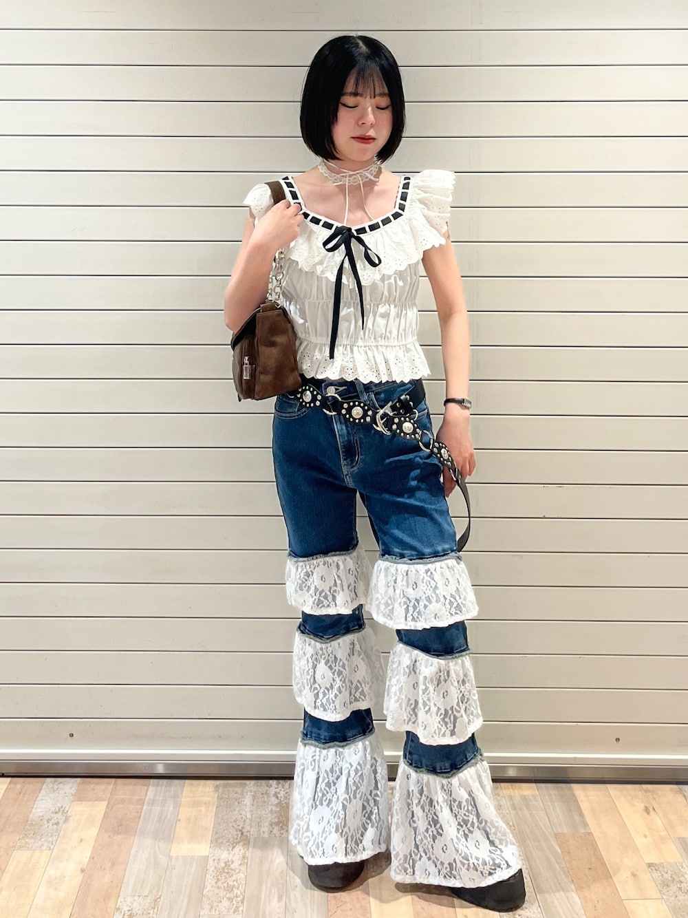 ホワイト系のシャツ/ブラウス、ブルー系のデニムパンツ、ブラウン系のハンドバッグを着用したレディースの春コーディネートの1枚目の写真