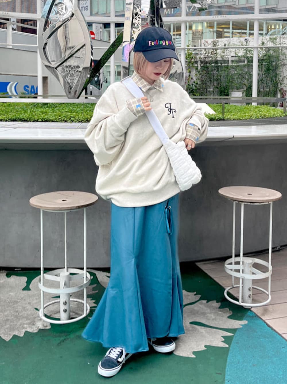 グレー系のスウェット、ベージュ系のシャツ/ブラウス、ブルー系のスカートを着用したレディースの秋コーディネートの1枚目の写真