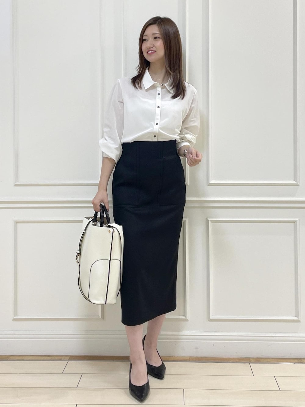 ホワイト系のトートバッグ、ブラック系のスカート、ホワイト系のシャツ/ブラウスを着用したレディースの秋コーディネートの1枚目の写真