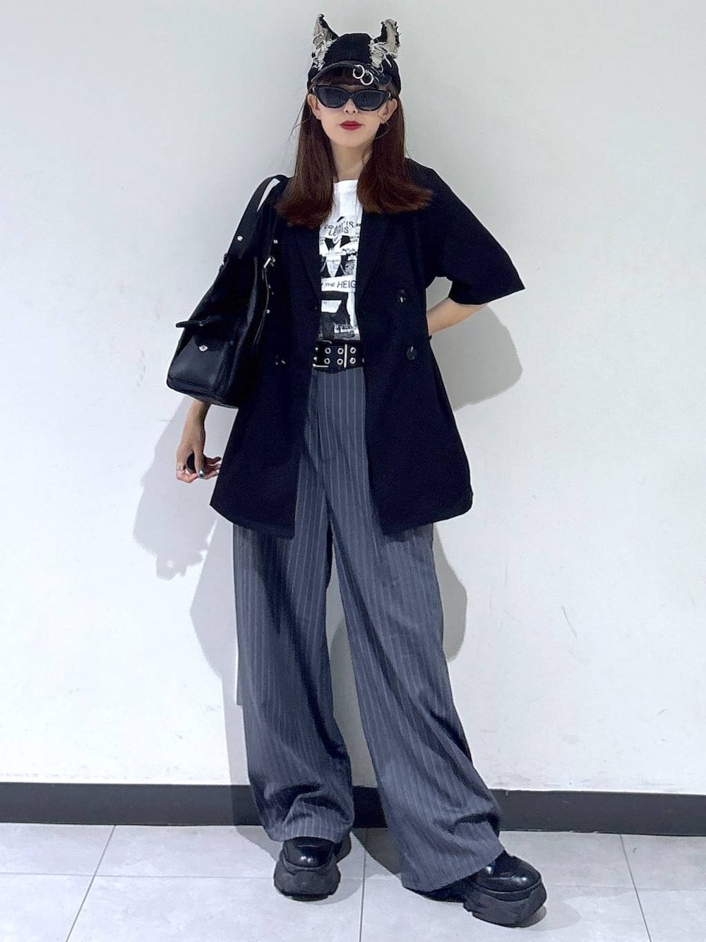 ホワイト系のTシャツ/カットソー、ブラック系のブーツ、ブラック系のハンドバッグを着用したレディースの夏コーディネートの1枚目の写真