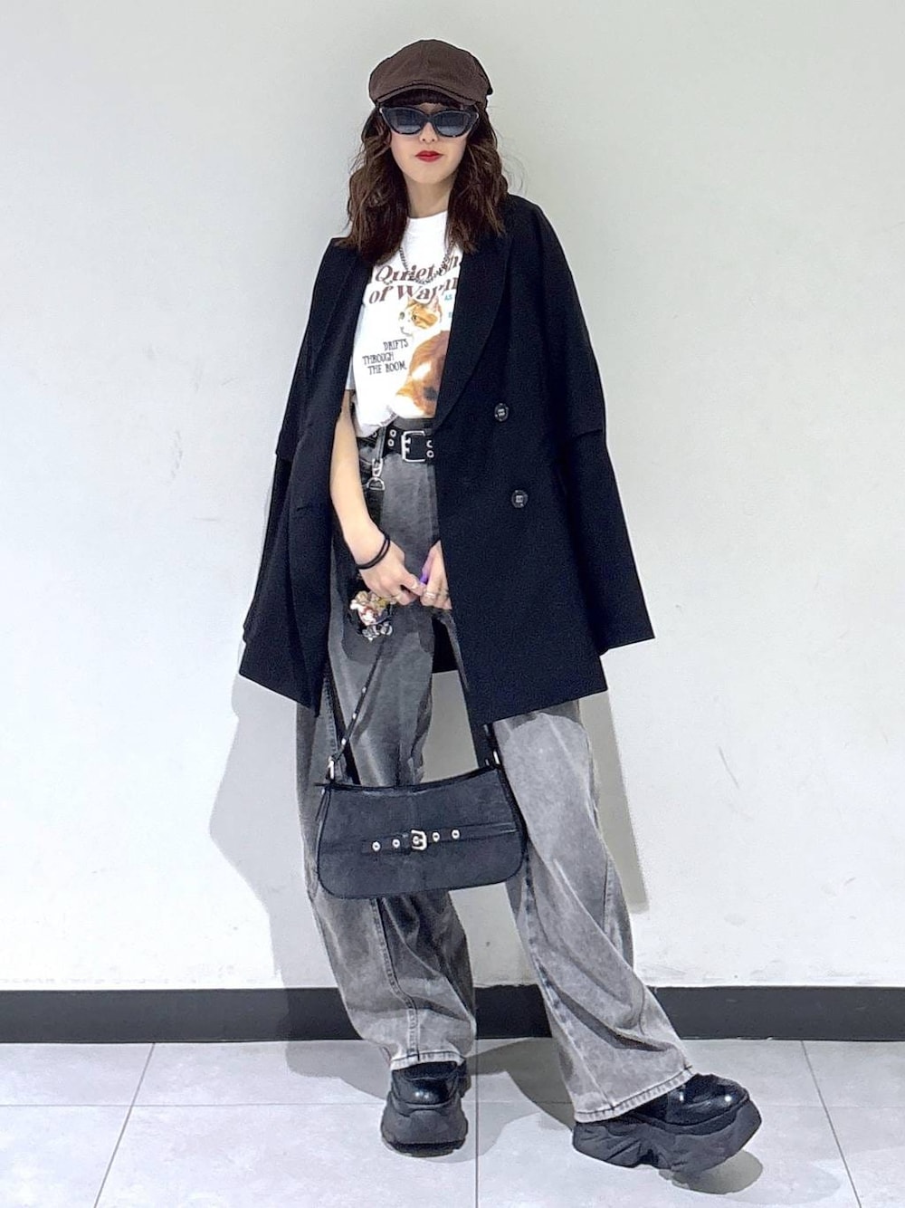 ブラック系のブーツ、ブラック系のハンドバッグ、ブラック系のテーラードジャケットを着用したレディースの春コーディネートの1枚目の写真